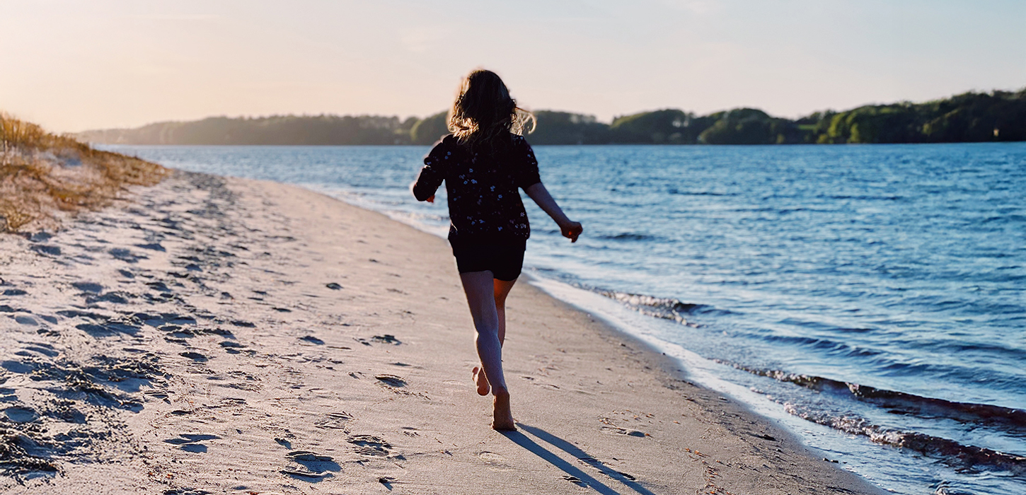 Pige løber på stranden i Middelfart