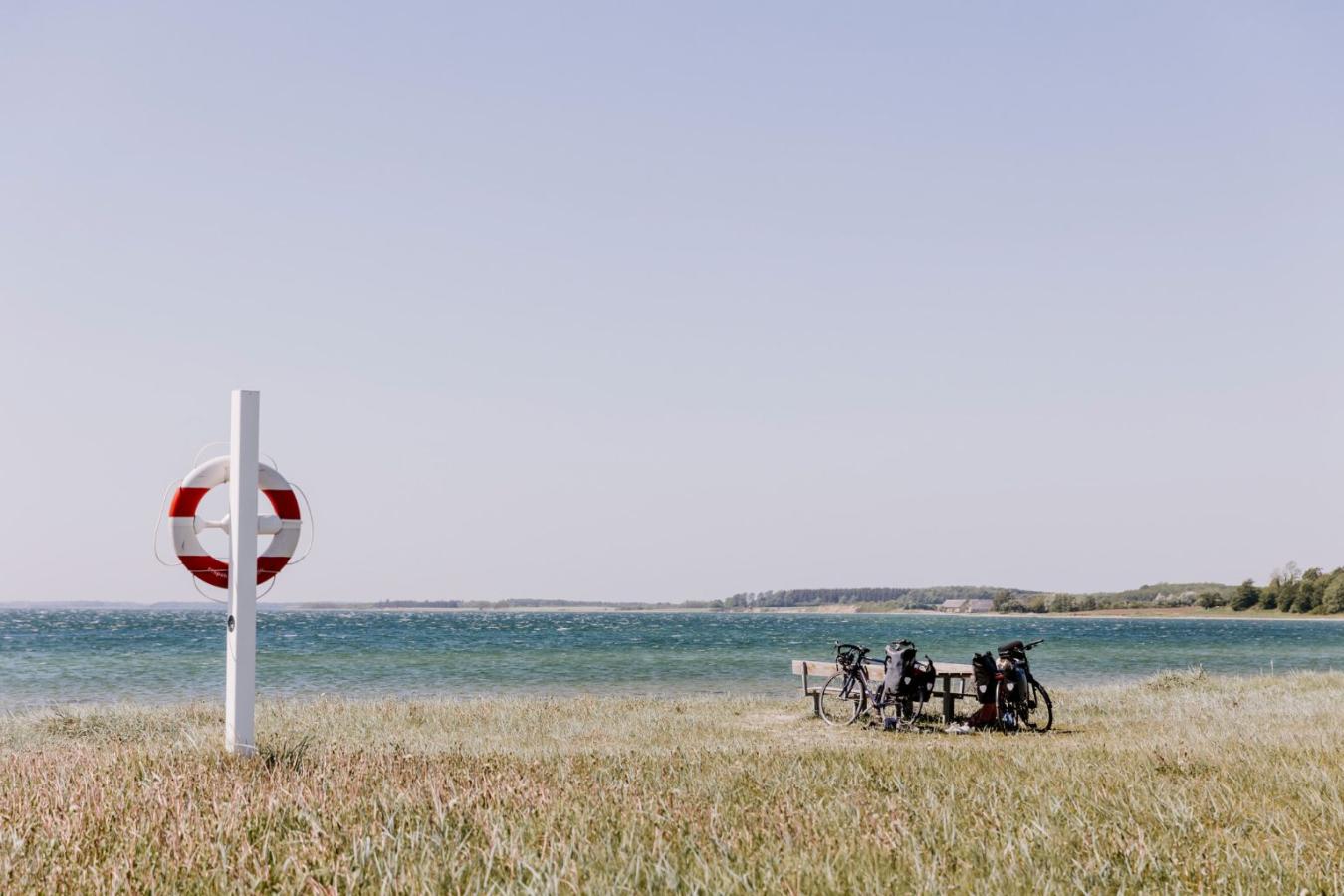 To cykler parkeret ved stranden på en sommerdag. cyklerne står op af et bordebænkesæt